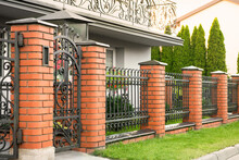 Beautiful Brick Fence With Iron Railing Outdoors