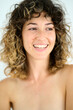 © Guille Faingold/Stocksy - Topless woman with toothy smile.