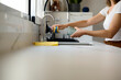 © Guille Faingold/Stocksy - Woman washing glass in sink.