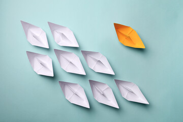 Canvas Print - Yellow paper boat among others on light background, flat lay. Uniqueness concept