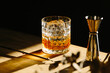 © Heleno - whiskey drink on a wooden table with a barspoon and a jigger on black background