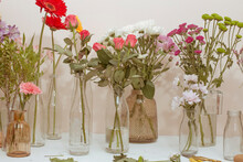 A Variety Of Flowers In Vases On The Table. 
