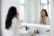 © Maxim VDN/Stocksy - Woman in the bathroom
