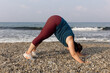 © Aleksei Toropov/Stocksy - Young woman doing yoga on the beach