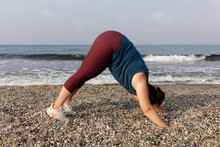 Young Woman Doing Yoga On The Beach