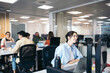 © Pedro Merino/Stocksy - Office colleagues working in a coworking space with laptops