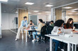 © Pedro Merino/Stocksy - Group of office colleagues working cooperatively in a coworking