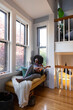 © Raymond Forbes LLC/Stocksy - Black Girl at home relaxing listens to music with ukulele