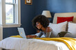 © Raymond Forbes LLC/Stocksy - African American Lifestyle Girl relaxing at home with laptop computer