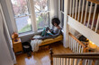 © Raymond Forbes LLC/Stocksy - African American Girl relaxing at home reading book in cozy nook