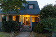 © Raymond Forbes LLC/Stocksy - Exterior front of home with porch at dusk with Halloween decorations