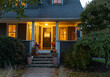 © Raymond Forbes LLC/Stocksy - Exterior front of home with porch at dusk with Halloween decorations
