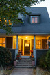 © Raymond Forbes LLC/Stocksy - Exterior front of home with porch at dusk with Halloween decorations