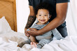 © Kristen Curette & Daemaine Hines/Stocksy - A father changing his baby's clothes