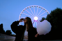 Woman In Amusement Park With Ferris Wheel
