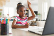 © Wavebreak Media - African american girl sitting at table, using laptop for online lesson