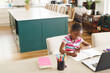 © Wavebreak Media - African american girl sitting at table, using laptop for online lesson