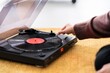 © Studio Marmellata/Stocksy - Crop woman using record player on floor