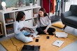 © Studio Marmellata/Stocksy - Joyful multiracial women choosing LP record at home