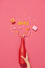 Open Bottle Of Champagne On Red Background Decorated With Confetti