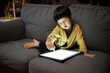 © ChaoShu Li/Stocksy - Cute little Asian boy painting electronically at home