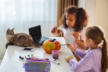 Children Make Pumpkin Crafts For Halloween At Home In The Living Room