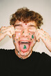 © BONNINSTUDIO/Stocksy - User-generated content man with Christmas stickers covering eyes