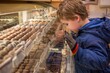 © Mel Karlberg/Stocksy - Kid staring through candy display case