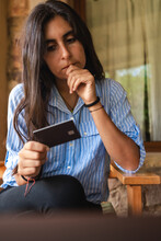 Worried Woman Looking At Her Credit Card