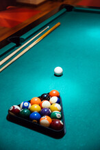 Balls In Rack On Pool Table In Club And Wooden Stick