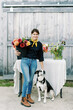 © Serena Burroughs/Stocksy - florist standing in front of her barn with fresh cut annuals