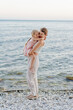 © Sergey Narevskih/Stocksy - Woman hugging child on beach
