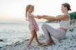 © Sergey Narevskih/Stocksy - Woman with child playing together on seashore
