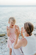 © Sergey Narevskih/Stocksy - Woman playing with child on beach