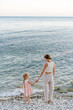 © Sergey Narevskih/Stocksy - Woman and child holding hands on seashore
