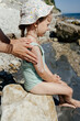 © Sergey Narevskih/Stocksy - Woman putting sunscreen on child on beach