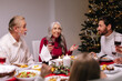 © Oleksii Syrotkin/Stocksy - Discuss  conversation Xmas tree family toasting wine celebration