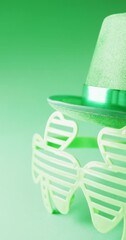 Sticker - Vertical video of of st patrick's green hat and shamrock glasses with copy space on green background