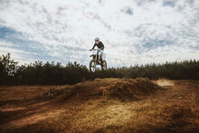 Young Man On Dirt Bike Jump In Blue Sky