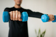 © Cavan Images - Young Man Lifting Dumbbells at Home