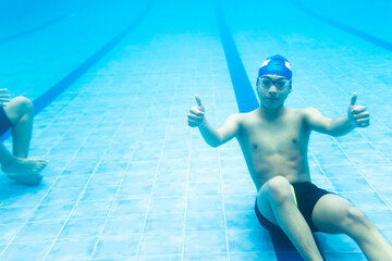 Wall Mural - latin young teenager man swimmer athlete wearing cap and goggles in a swimming underwater training In the Pool in Mexico Latin America	