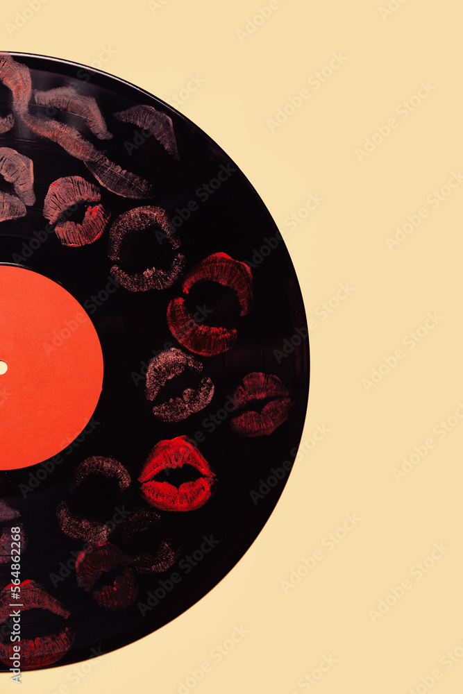 Vinyl record with lipstick kiss marks on yellow background
