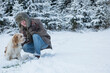 © Cavan Images - Young man with dog in snowy landscape in winter, Bavaria, Germany