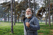 © Jovo Jovanovic/Stocksy - Determined senior runner jogging against trees in park