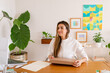 © ByLorena/Stocksy - Pretty entrepreneur with shipping box at home office