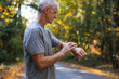 © Rob and Julia Campbell/Stocksy - Man looking at watch before going for a run.