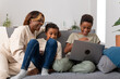 © Bisual Studio/Stocksy - Happy mother and sons watching video together