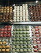 © Julie Meme/Stocksy - UGC, rows of colourful macarons in the market
