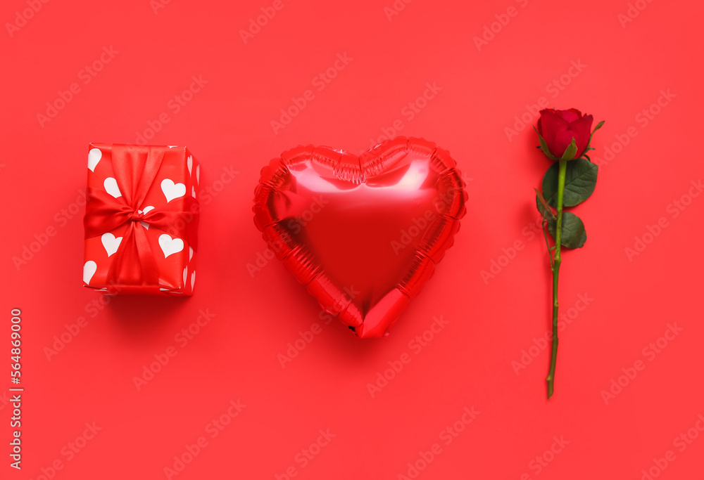Heart shaped balloon, rose flower and gift box on red background. Valentine's Day celebration