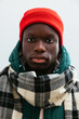 © BONNINSTUDIO/Stocksy - Serious man in warm jacket and red wool hat